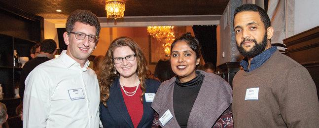 Two women and two men pose at the Southern California holiday party